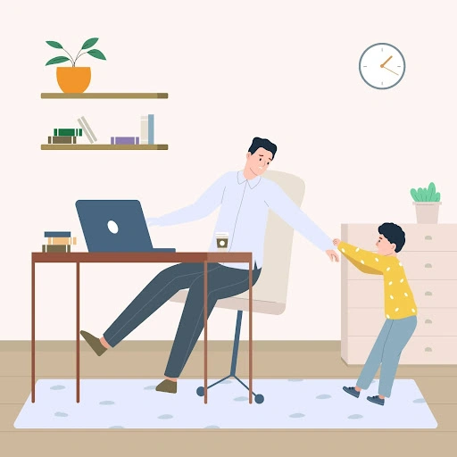 a parent working on a laptop at a home desk while a child reaches out for attention